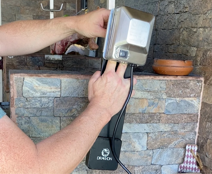 Carne asándose al palo con intenso aroma a humo con Kit Drakhon